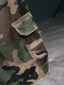 Close-up detail of camouflage cargo shorts showing the pocket flap and fabric texture.