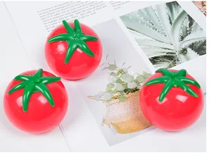 Dettaglio di tre palline antistress a forma di pomodoro rosso su una rivista bianca