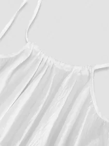 Close-up detail of white pleated fabric texture on a summer beach holiday maxi dress