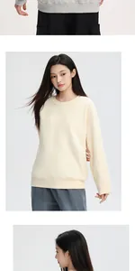 Detail of a thick cream crewneck sweatshirt featuring a loose fit and soft fleece texture.