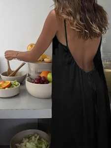 Back view detail of a black backless spaghetti strap maxi dress in crinkle fabric