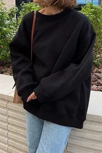 Dettaglio della felpa girocollo nera oversize da donna con vestibilità rilassata.