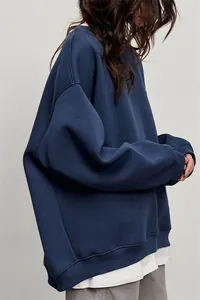Vista laterale di felpa girocollo blu scuro oversize da donna con maglietta bianca a strati