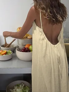 Detailed back view of a beige backless pleated camisole long dress for beach vacation.