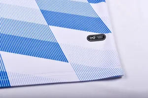 Close-up of blue and white geometric pattern soccer jersey fabric with hem label