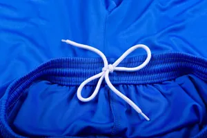 Close-up of blue sports shorts waistband with white adjustable drawstring detail