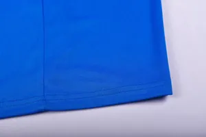 Close-up of blue breathable mesh fabric and double-stitched hem on sports jersey