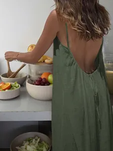 Detailed view of a green backless spaghetti strap maxi dress for summer beach wear.