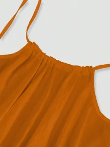 Detailed view of bright orange ice silk ruched neckline and straps of a beach dress.