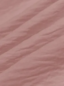 Macro view of pink ice silk wrinkled fabric texture for summer beach vacation dress