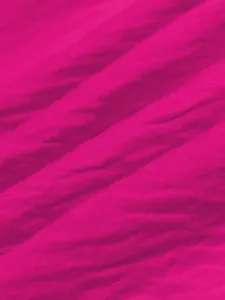 Detailed close-up of bright pink ice silk crinkle fabric for summer beach dresses