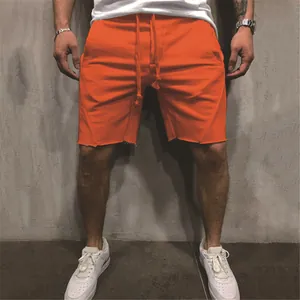 Vibrant men's orange athletic shorts with a raw hem and drawstring for fitness wear