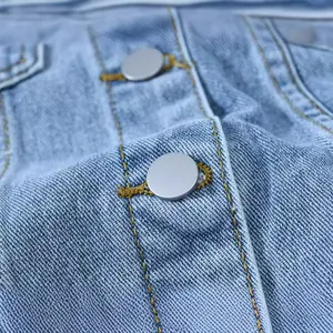 Detailed close-up of a vintage blue denim jacket with silver buttons and yellow stitching