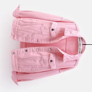 Vista detallada de una chaqueta vaquera rosa corta con botones de metal y bolsillos.