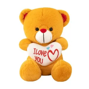 Ginger yellow plush teddy bear holding a white heart with I Love You red embroidery