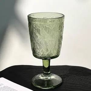 Gros plan élégant d'un verre à pied vert orné d'un motif de feuilles en relief raffiné