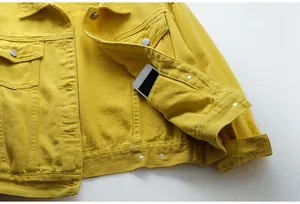 Primer plano detallado del bolsillo interior funcional de una chaqueta vaquera amarilla.
