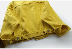 Primer plano de una chaqueta vaquera corta amarilla con botones y costuras