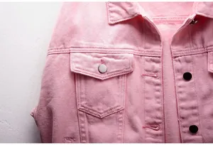 Vista detallada de una chaqueta vaquera rosa mostrando la textura y botones plateados