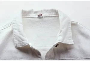 Detalle del cuello de una chaqueta vaquera blanca mostrando la textura y costuras