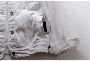 Primer plano del detalle del bolsillo lateral de una chaqueta vaquera blanca de calidad