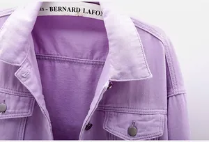 Detalle de cerca del cuello de una chaqueta vaquera violeta con botones metálicos