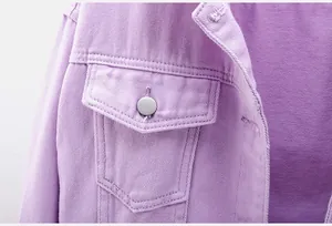 Detalle de cerca de una chaqueta vaquera morada con bolsillo y botón de metal