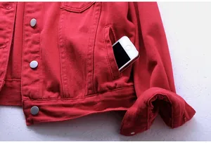 Vista detallada del bolsillo lateral de una chaqueta vaquera roja con un smartphone.