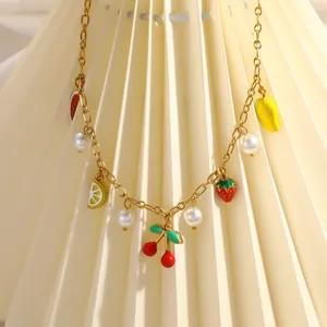 Detail of 18K gold plated necklace with colorful fruit charms and pearls.