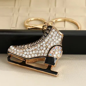 Macro view of a luxury gold-tone ice skate keychain featuring sparkling white rhinestones.