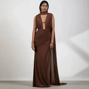 Dettaglio di un elegante abito lungo drappeggiato marrone con mantella molto alla moda