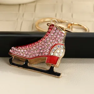 Detailed close-up of a sparkling pink rhinestone ice skate keychain with red enamel accents