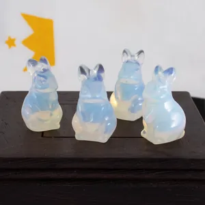 Macro view of four translucent opalite rabbit crystal carvings on a dark wood base.