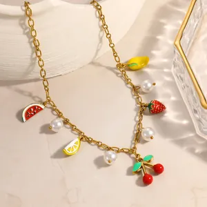 Detail view of colorful fruit and pearl charms on a gold-plated stainless steel necklace
