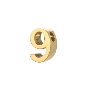 Detailed view of a gold stainless steel number 9 charm for DIY jewelry