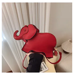 Vibrant red elephant-shaped PU leather cartoon shoulder bag shown being held by hand