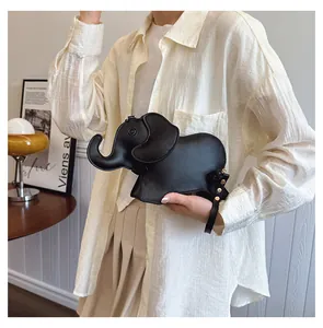 Detailed view of a cute black cartoon elephant-shaped PU handbag held by a model