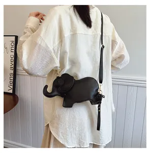 Lifestyle view of a cute black elephant-shaped PU leather crossbody bag worn on a model.