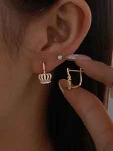 Close-up of elegant crown-shaped earrings with clear stones and secure lever-back clasp.