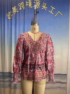 Détail d'un chemisier bohème à fleurs, col en V et manches longues avec liens à nouer