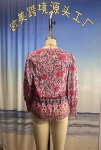 Détail de la vue arrière d'une blouse bohème à fleurs et manches longues sur un mannequin