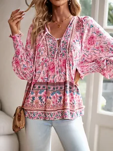 Détail d'une blouse bohème fleurie avec col en V à nouer et poignets élastiques