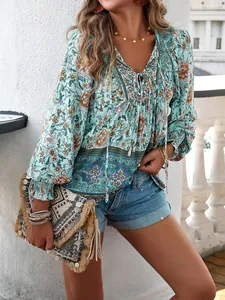 Détail d'une blouse bohème à imprimé fleuri avec col en V et pochette à pompons.