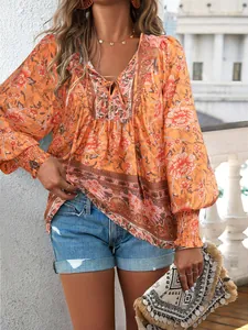 Détail de la blouse bohème à fleurs avec col en V, liens et manches bouffantes