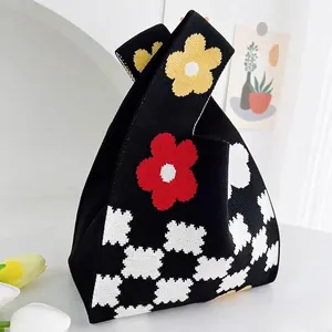 Borsa a mano in maglia nera con motivi floreali rossi e gialli e motivi a scacchi