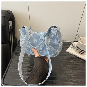 Distressed denim shoulder bag with star patterns and frayed edges for casual fashion.