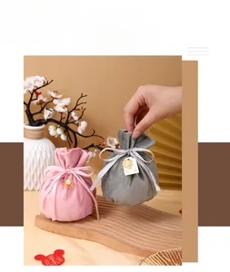Detail showing elegant velvet drawstring gift bags with pearl and golden charms