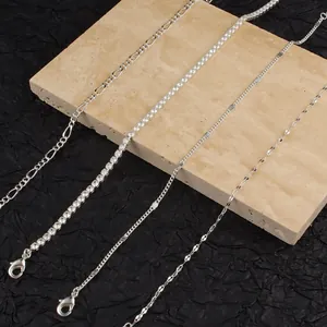 Detail shot showing a variety of silver-tone chains on a travertine stone display.