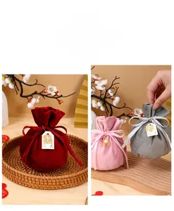 Detail view of round velvet wedding favor bags with elegant ribbon and gold charm.