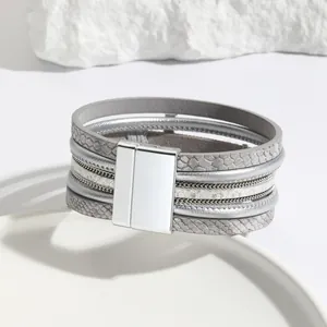 Close-up detail of multi-layer leather bracelet featuring silver textures and magnetic clasp